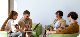 Коллеги в офисе обсуждают страхование сотрудников от несчастных случаев, работая за ноутбуками