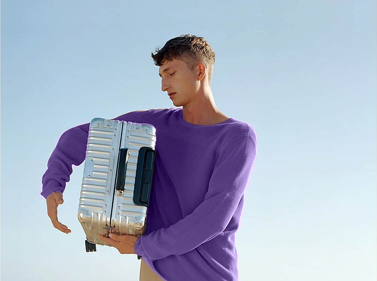 Мужчина с чемоданом в руках оформил страхование от задержки или отмены рейса перед путешествием